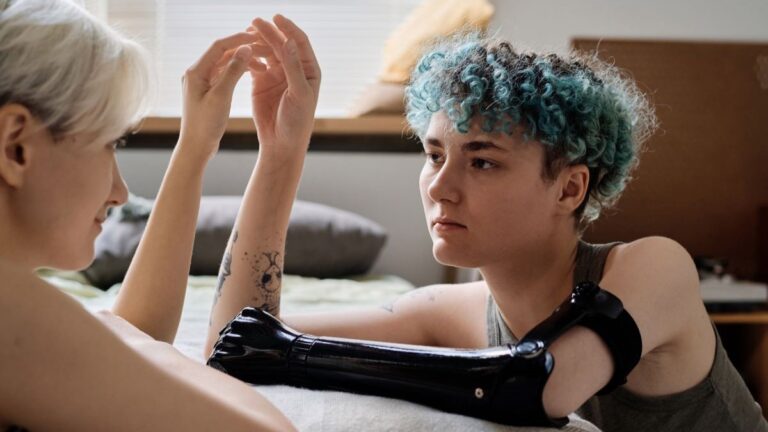 couple on bed one has a prosthetic arm