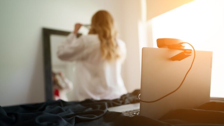 blonde cam model gets ready for work in front of a mirror