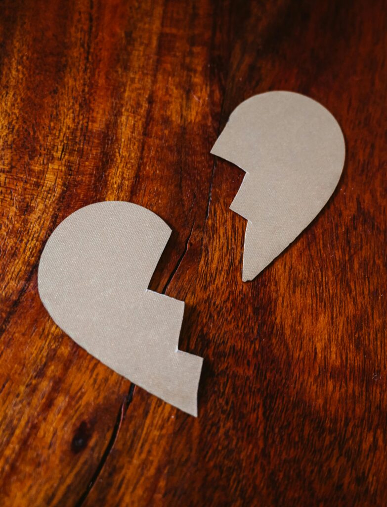 A heart shaped paper, cut into two halves with a jagged line. They could represent divorce.