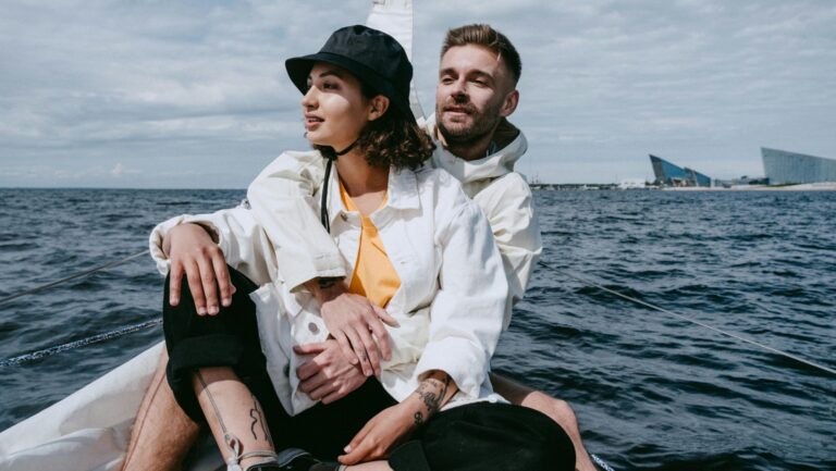 couple on a boat in the ocean together, sailing.