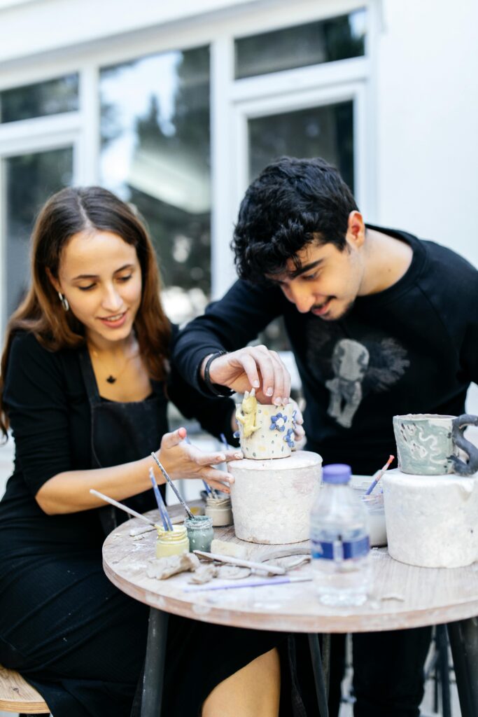 A diverse couple doing a pottery class together. This is a self-expansion activity. 