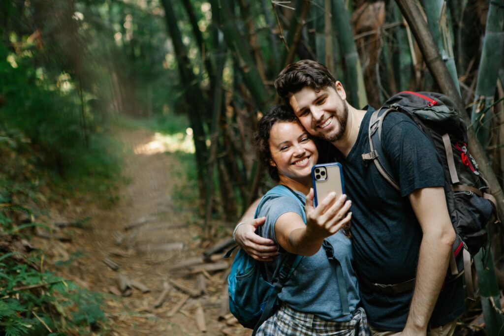 A couple taking a selfie on a hiking trail. 