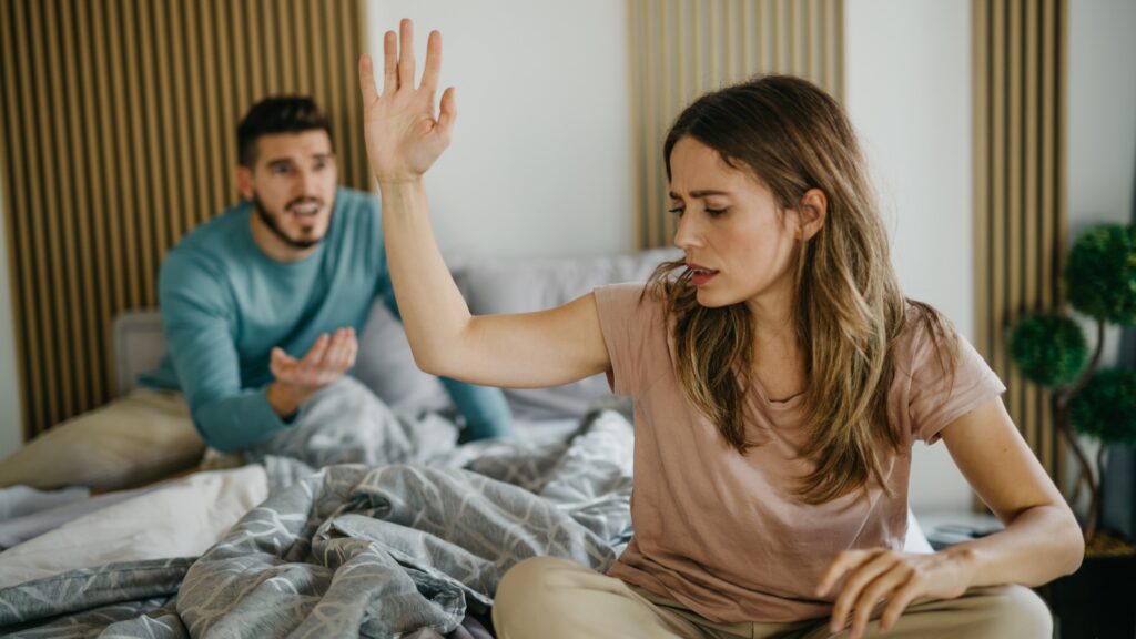 young couple in bed fighting