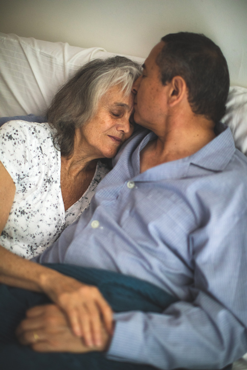 Affectionate senior latin couple in the bed in early morning