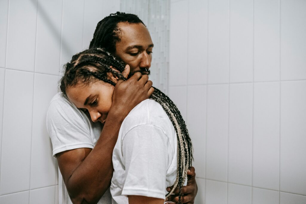 Man giving his female partner affectionate touch through a hug. 