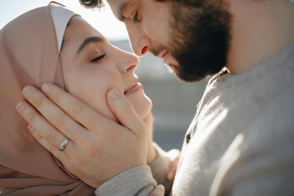 Male partner embraces his female partner with a look of compassion and love. They look peaceful. 