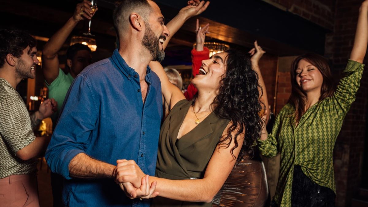 couple dancing together amid a crowd of others at a party