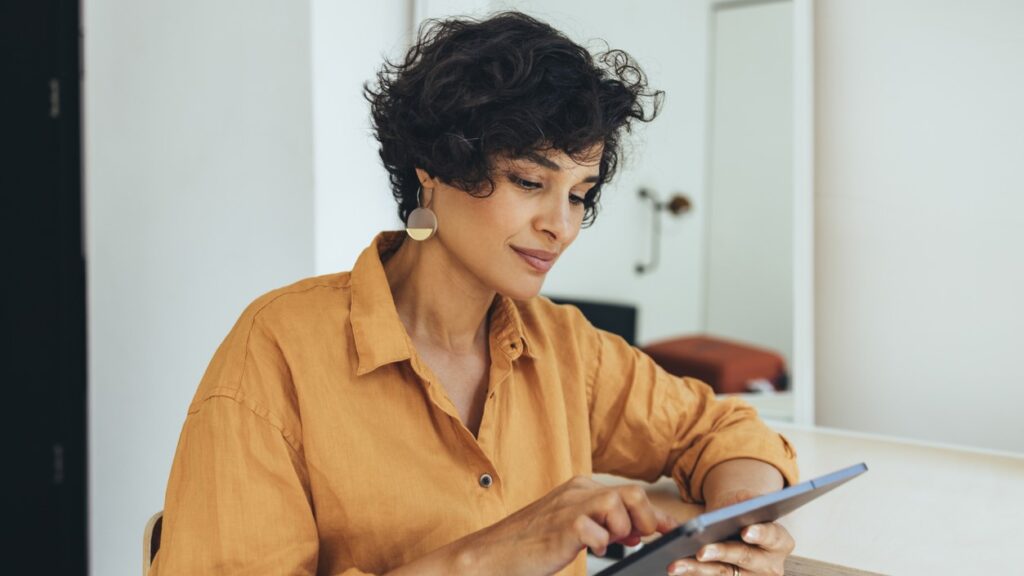 A young attractive woman sitting and using a tablet