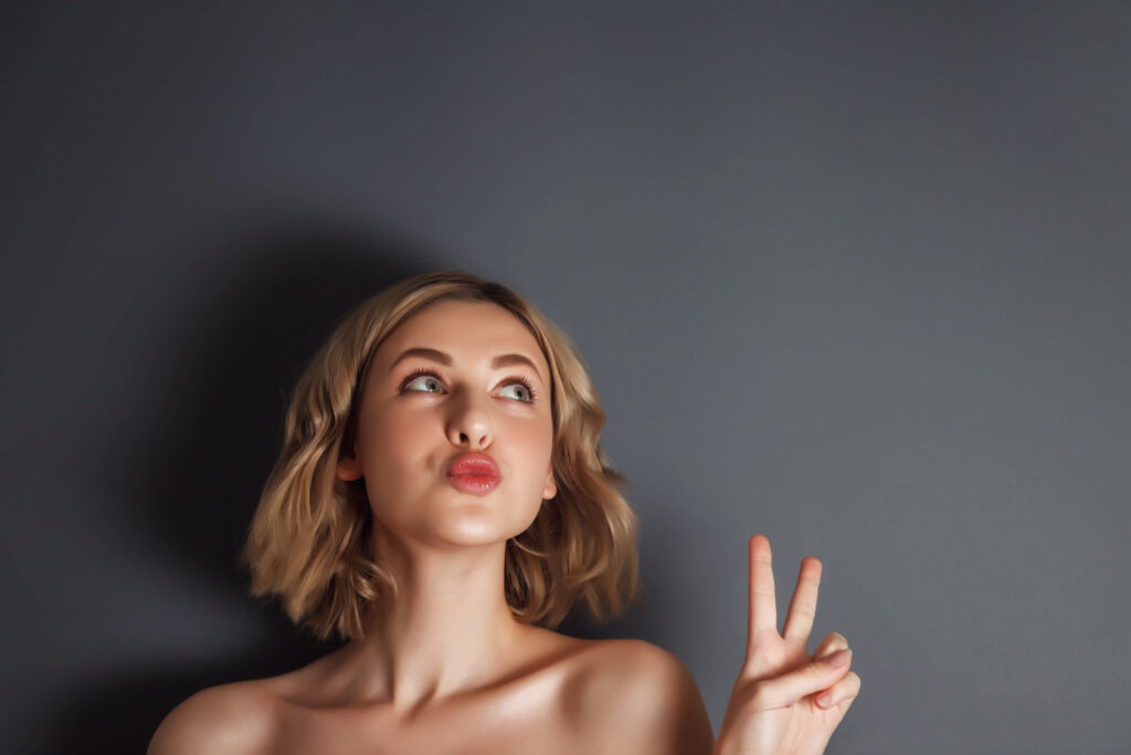 closeup pretty portrait happy woman shows peace sign.