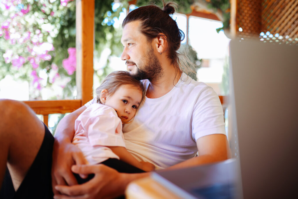 Father and daughter snuggled on chair together.