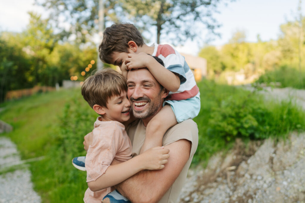 Father spending quality time with his boys outdoors by a river.