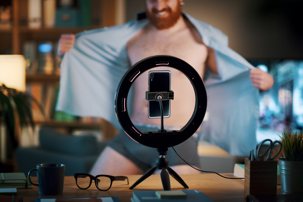 young man stripping in front of the camera