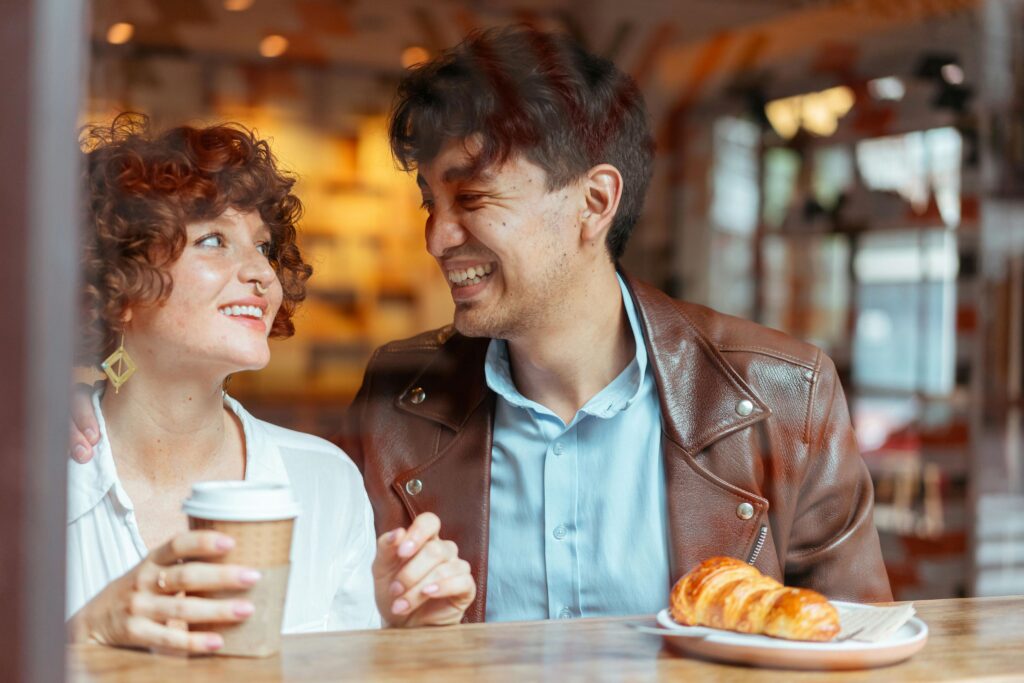 a couple in a coffee shop looking lovingly at each other